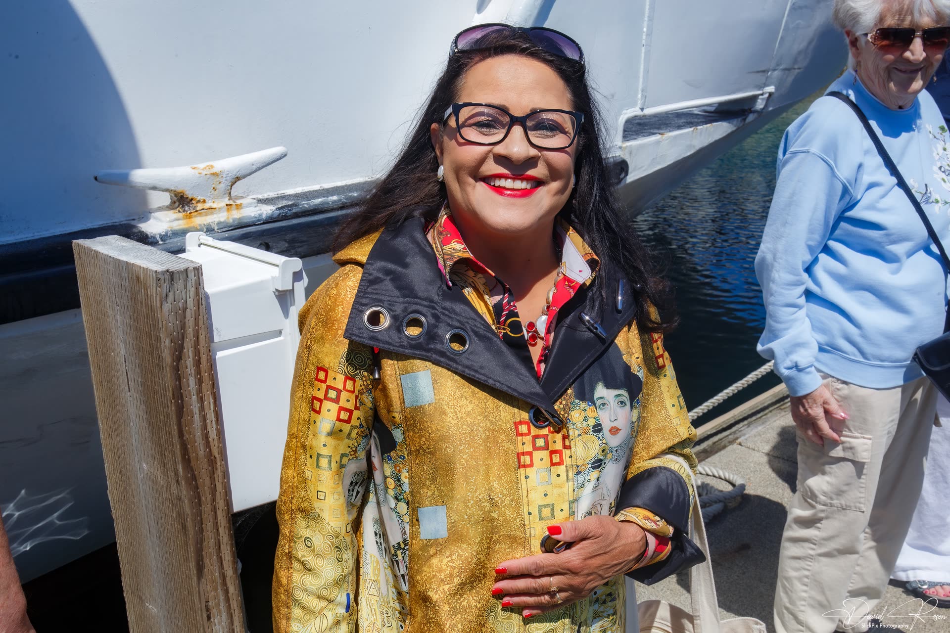 A smiling cruise guest stands near the boarding area.
