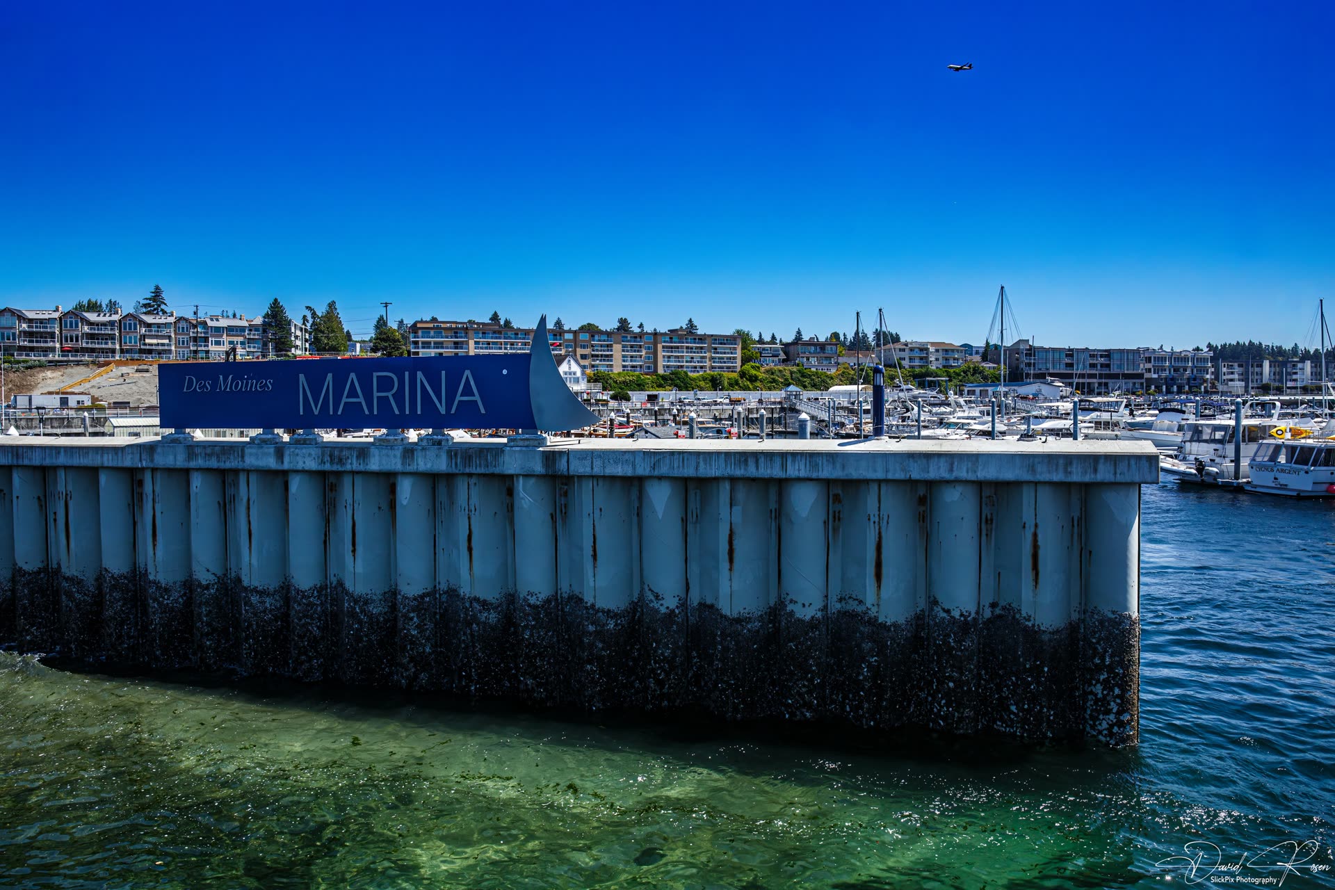 Wide view of passengers on deck with Des Moines Marina in the background.