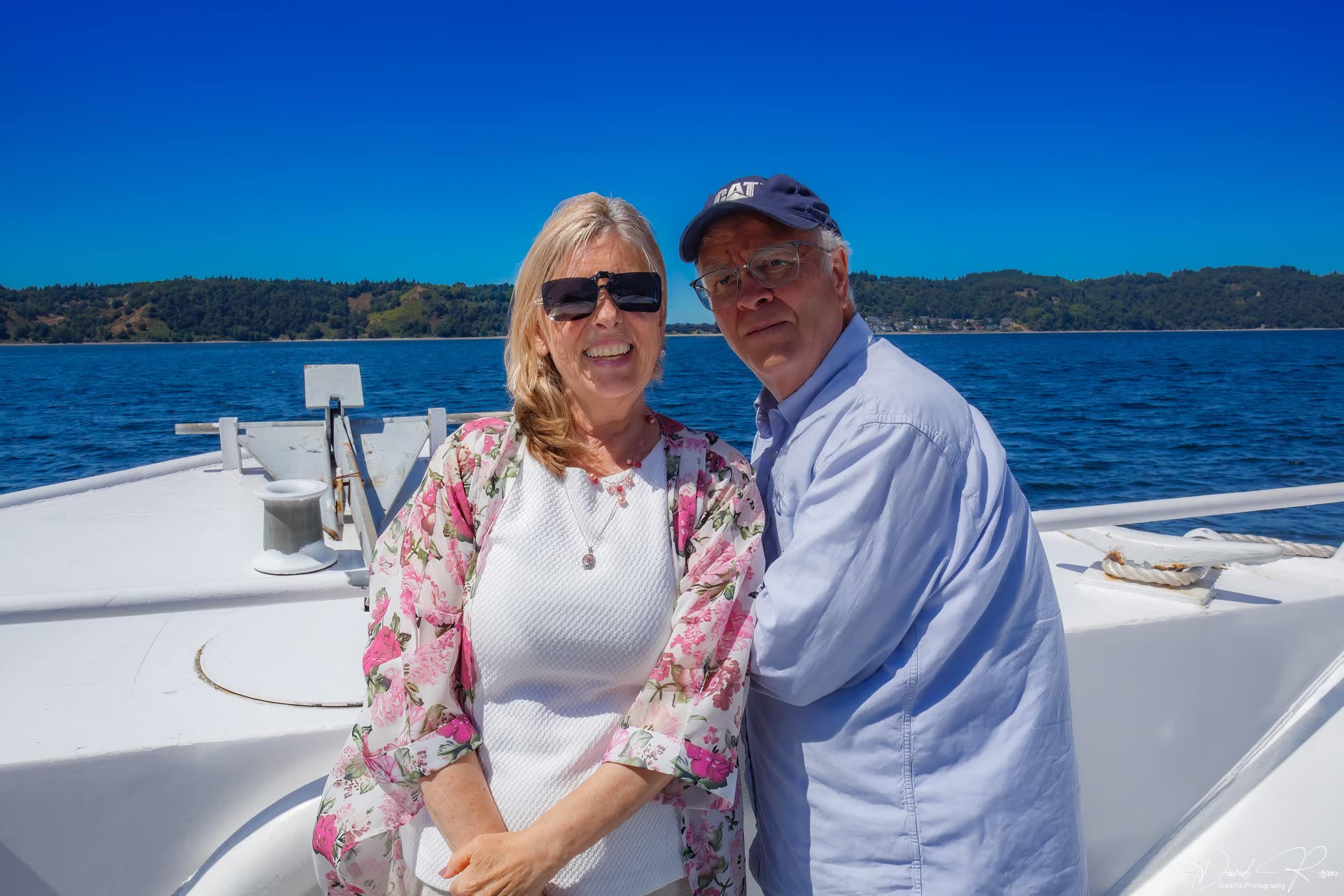 Two guests pose together on the open bow deck.