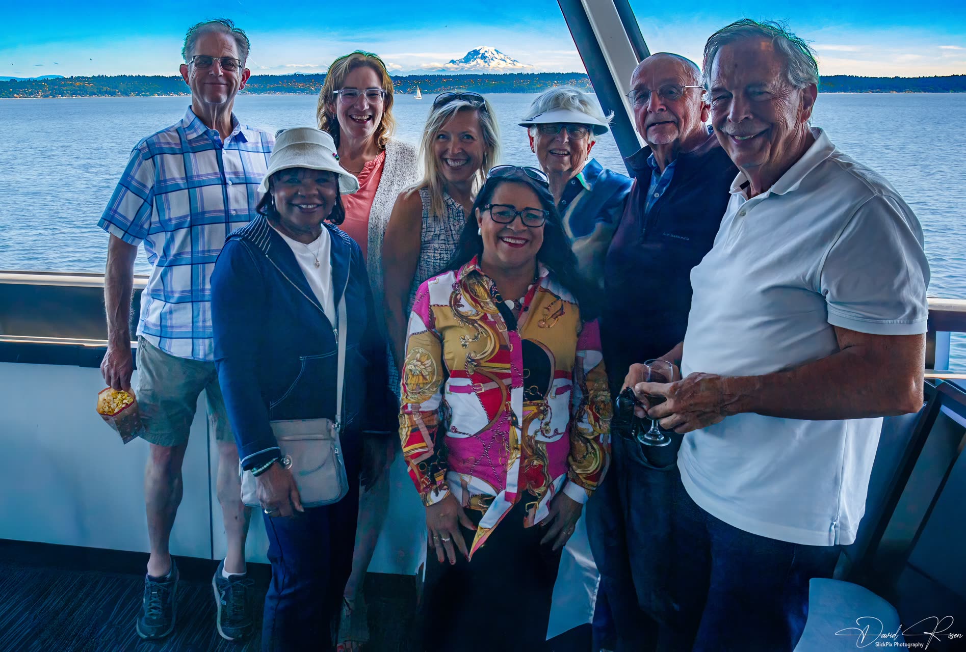 A group of smiling cruise guests poses together inside the vessel.